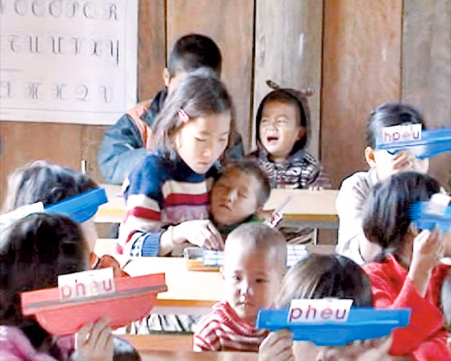 HS vừa ngồi học vừa trông em