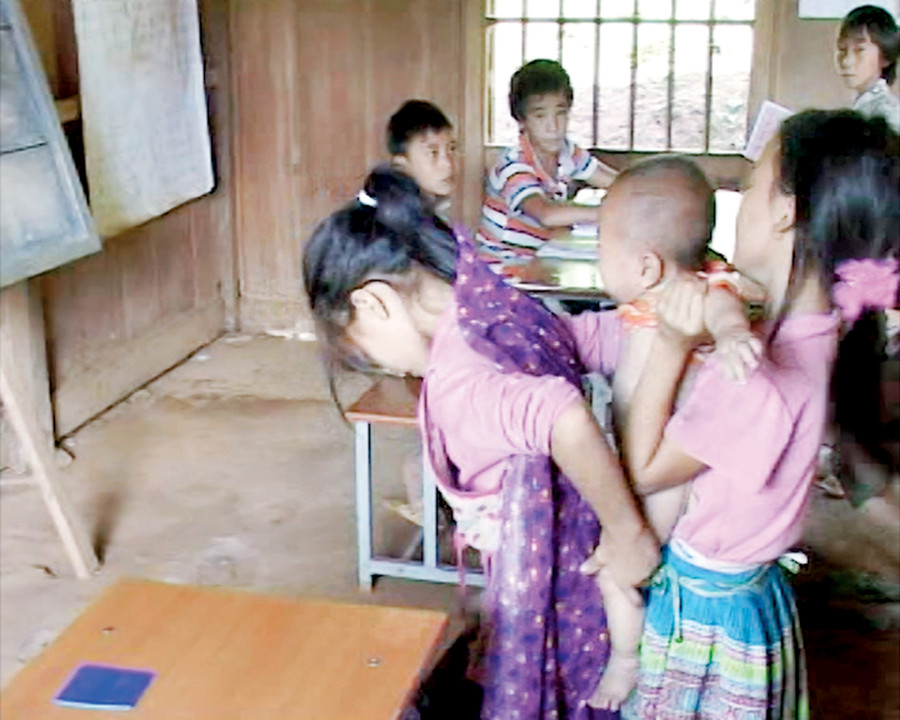 Hỗ trợ bạn thay đồ cho em trên lớp học Hỗ trợ bạn thay đồ cho em trên lớp học