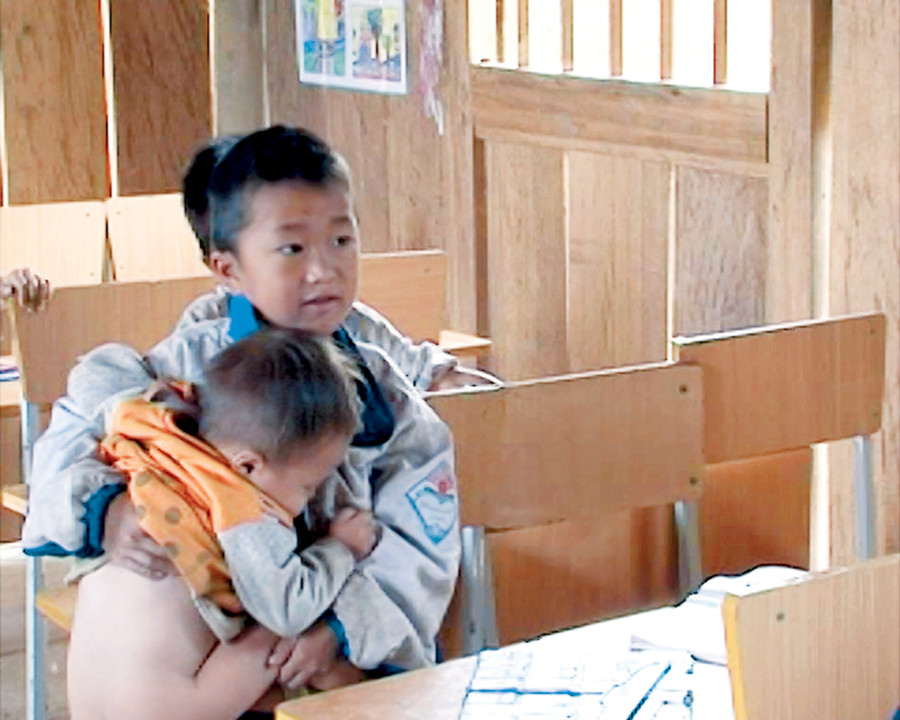 HS tiểu học vừa ru em ngủ vừa học bài HS tiểu học vừa ru em ngủ vừa học bài