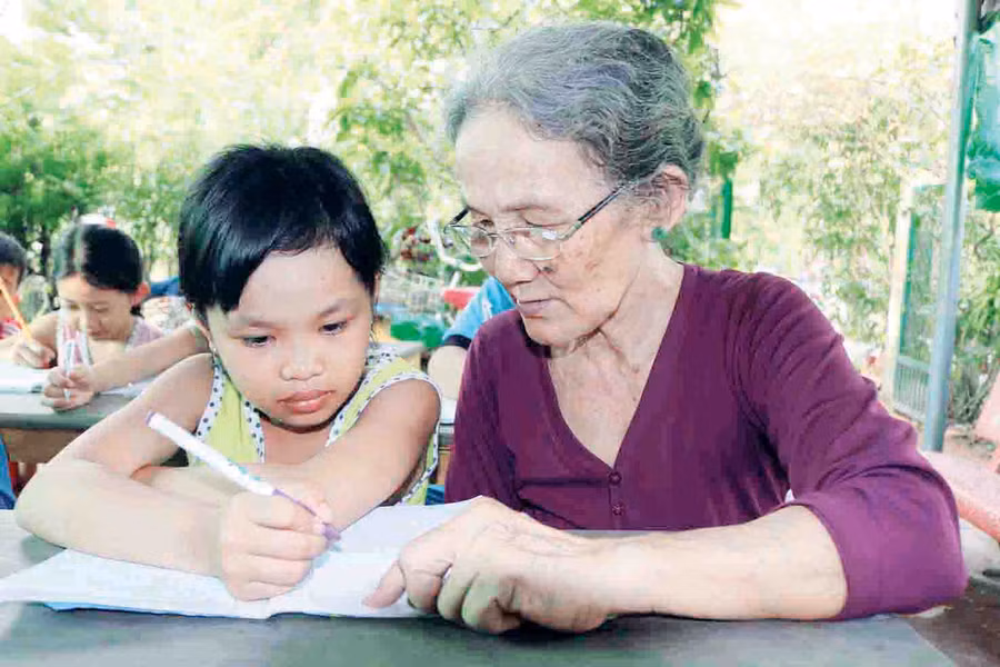 Cô Ba Đỏ cần mẫn chỉ bài cho từng em HS