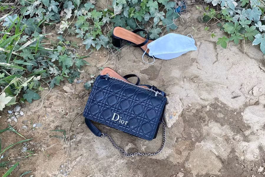 Chiếc túi xách và dép người phụ nữ để lại trên bờ.