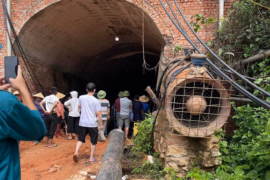 Người dân đi vào hầm lò khai thác quặng của doanh nghiệp.