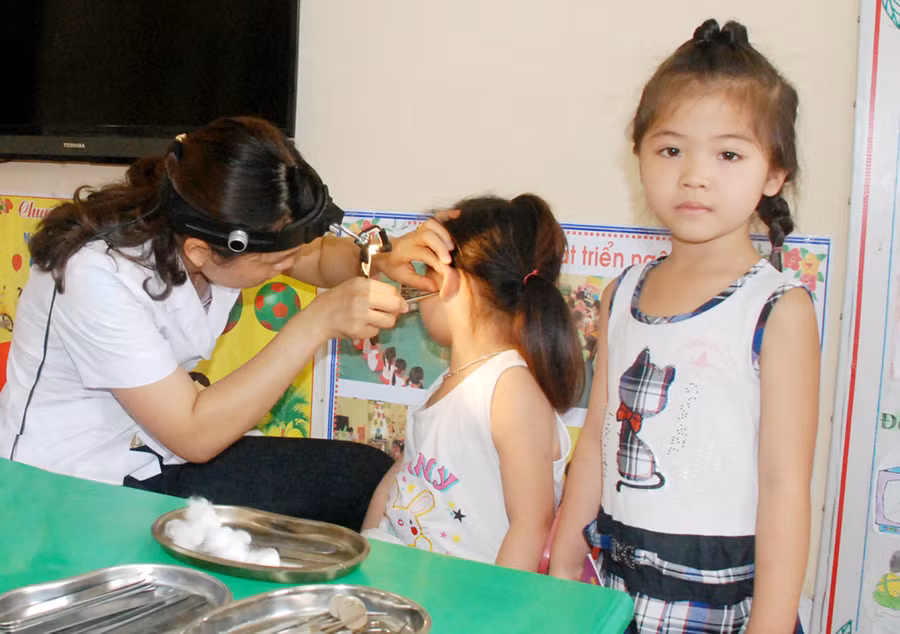 Nhân viên y tế học đường thăm khám sức khỏe học sinh mầm non. Ảnh: Hà Thành