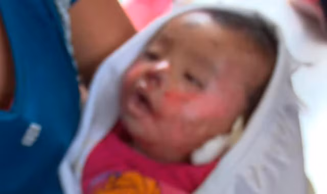 Bé 7 tháng tuổi choàng mở mắt trong vòng tay mẹ vào tang lễ của mình