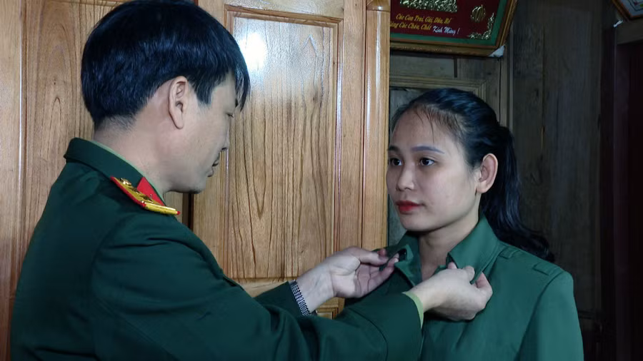 Cựu sinh viên Bàn Thị Thanh Bình được bố chỉnh trang bộ quân phục trước khi lên đường nhập ngũ. (Ảnh: KT)