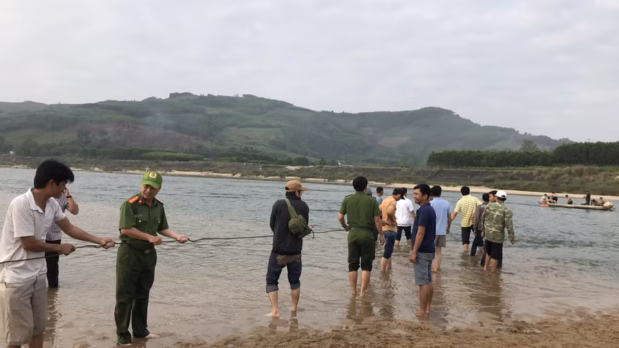 Lực lượng chức năng cùng người dân nỗ lực trục vớt chiếc ôtô. Ảnh CQCA.