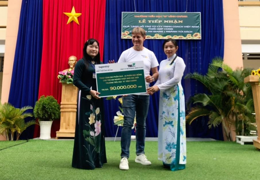 Đại diện Công ty TNHH Coach Việt Nam trao bảng tượng trưng quà và học bổng cho lãnh đạo Trường Tiểu học B Vĩnh Chánh (huyện Thoại Sơn, tỉnh An Giang). Đại diện Công ty TNHH Coach Việt Nam trao bảng tượng trưng quà và học bổng cho lãnh đạo Trường Tiểu học B Vĩnh Chánh (huyện Thoại Sơn, tỉnh An Giang).