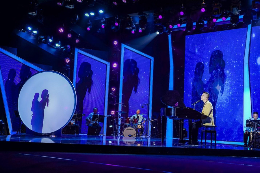 Hoàng Bách đệm đàn cho mẹ hát trên sân khấu được dàn dựng công phu. Hoàng Bách đệm đàn cho mẹ hát trên sân khấu được dàn dựng công phu.