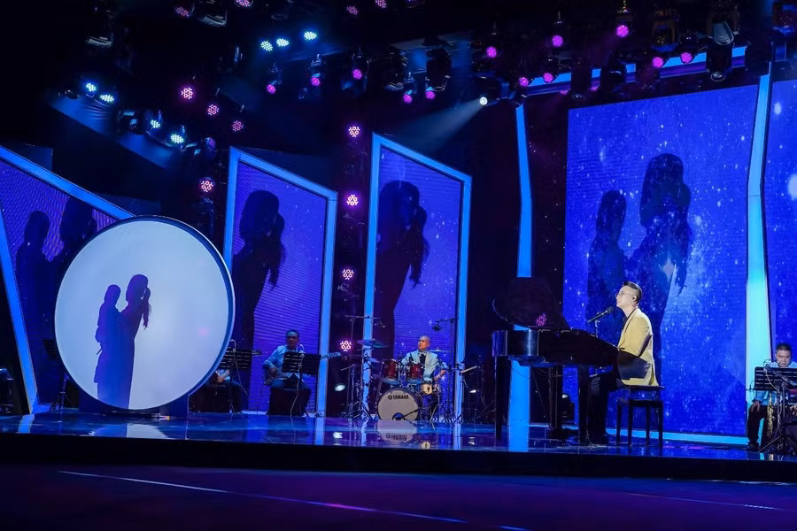 Hoàng Bách đệm đàn cho mẹ hát trên sân khấu được dàn dựng công phu. Hoàng Bách đệm đàn cho mẹ hát trên sân khấu được dàn dựng công phu.