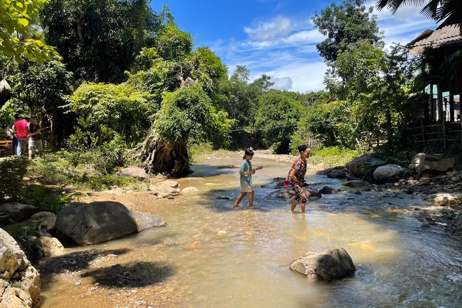 Vào mùa mưa lũ, nước suối dâng cao khiến giao thông chia cắt, các em học sinh bản Xốp Cốc không thể đến trường.