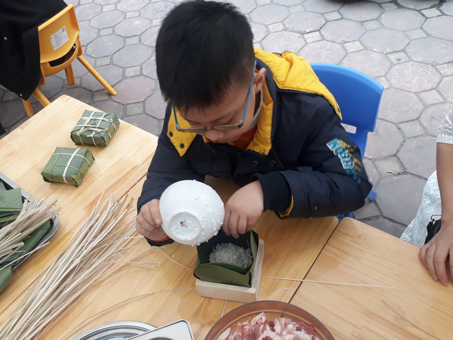 Tại Hội chợ Tết các bé được trải nghiệm cách gói bánh chưng,