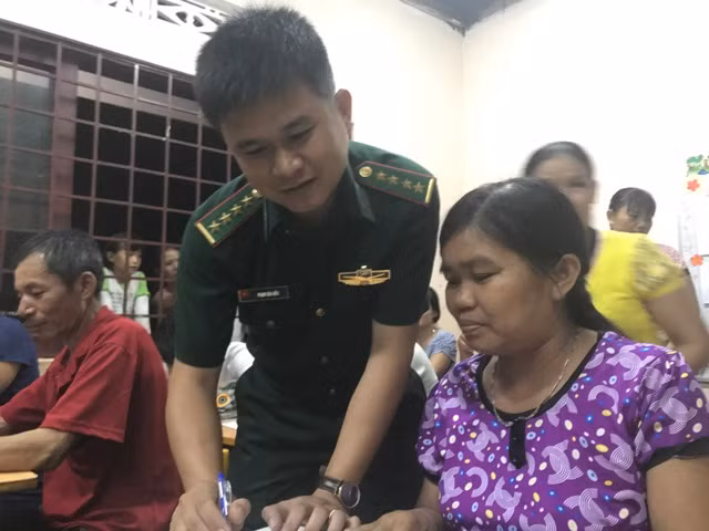  thầy giáo Phạm Văn Hiếu – chiến sĩ cán bộ công tác tại Đồn biên phòng huyện Ea Súp, tỉnh Đak Lak dạy xóa mù chữ cho dân.