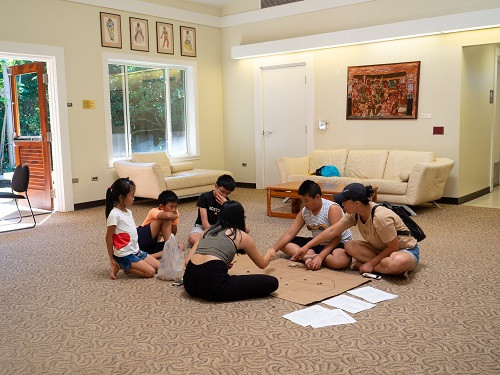 Kiều Ngân giới thiệu cho hai vị khách người Trung Quốc và các bạn nhỏ người Việt ở Hawaii cách chơi ô ăn quan. Kiều Ngân giới thiệu cho hai vị khách người Trung Quốc và các bạn nhỏ người Việt ở Hawaii cách chơi ô ăn quan. Ảnh: Thái Phạm