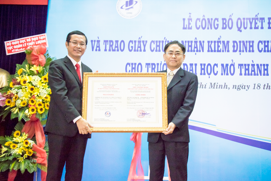 PGS.TS Nguyễn Hội Nghĩa-Phó Giám đốc ĐHQG TPHCM (phải) trao giấy chứng nhận đạt chuẩn kiểm định cho PGS.TS Nguyễn Văn Phúc-Hiệu trưởng nhà trường