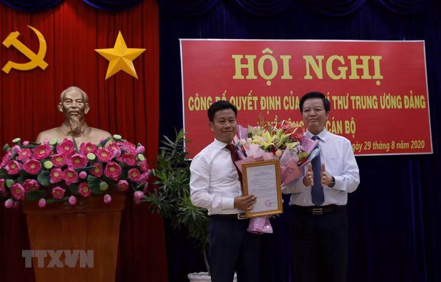 Ông Mai Văn Chính, Ủy viên Trung ương Đảng, Phó trưởng Ban Tổ chức Trung ương trao Quyết định của ban Bí thư cho ông Lê Quân. (Ảnh: Kim Há/TTXVN)