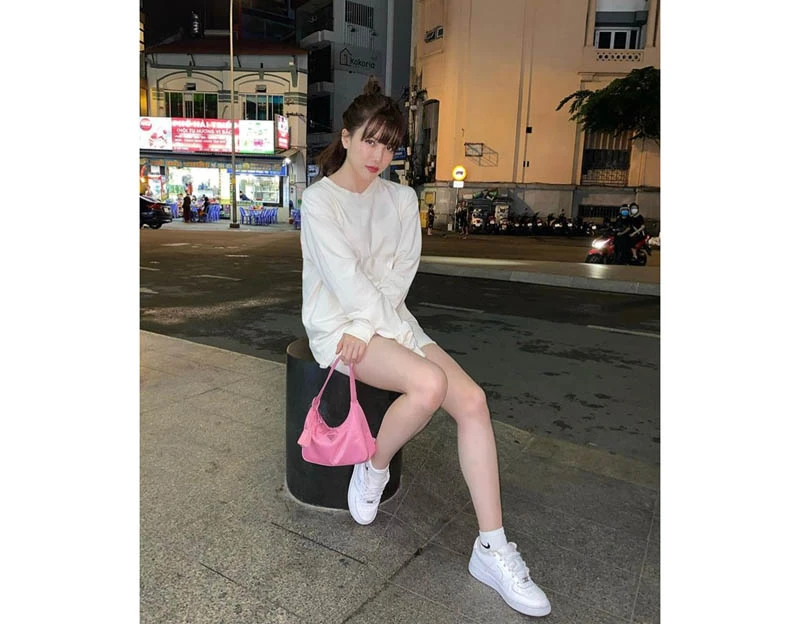 Cô em gái Thiều Bảo Trâm mặc cả set đồ gam màu tráng với áo sweater dáng dài mix cùng quần short, sneaker. Để tổng thể không nhàm chán cô còn mix thêm túi xách màu hồng tạo dấu ấn cho cả set đồ.