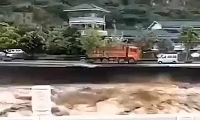 Chiếc xe tải đỏ trước khi rơi xuống dòng lũ dữ