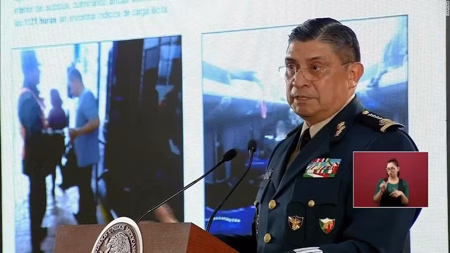 Trong một cuộc họp báo, Bộ trưởng Quốc phòng Mexico Luis Crescencio Sandoval González chiếu cho các phóng viên hình ảnh của chiếc xe buýt được chụp tại trạm kiểm soát quân sự, hơn một giờ trước khi các tay súng chặn nó lại