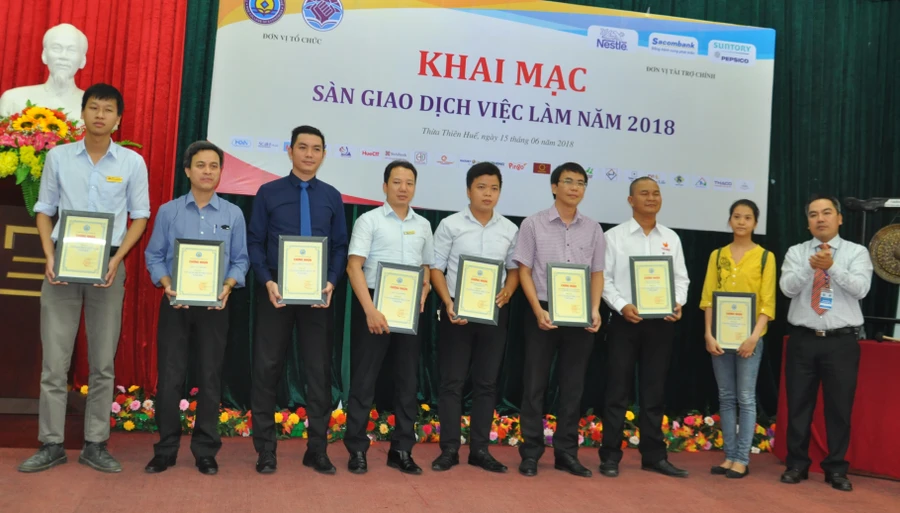 Trường ĐH Kinh tế (ĐH Huế) trao giấy chứng nhận cho các doanh nghiệp tham gia sàn giao dịch việc làm.