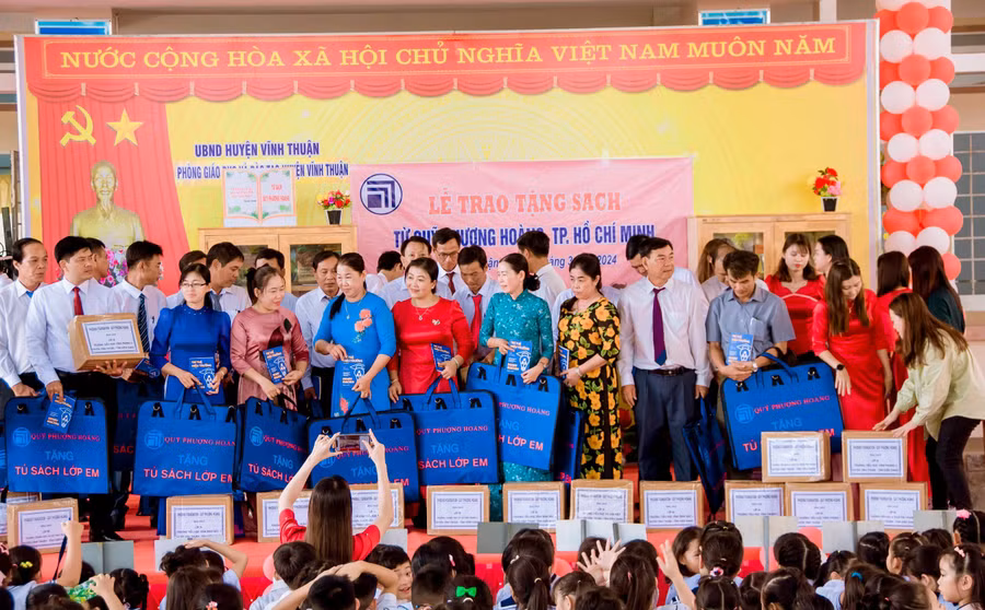 Đại diện Quỹ Phượng Hoàng TP Hồ Chí Minh trao tặng “Tủ sách lớp em” và túi đựng sách cho 22 trường Tiểu học và THCS trên địa bàn huyện.