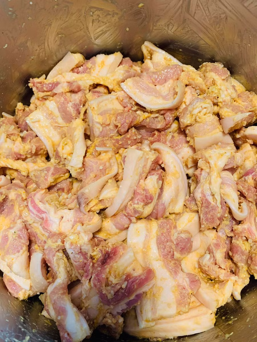 Đeo bao tay trộn đều gia vị cho thấm. Thịt đã ướp đậy kín nắp cho vào tủ lạnh, để khoảng 2h là nướng được.