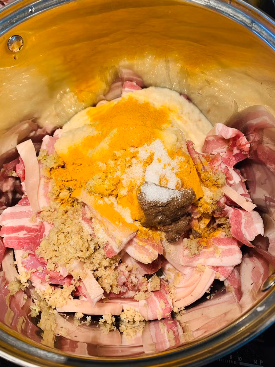 Cho mẻ xay nhuyễn, riềng sả giã nhỏ, bột nghệ (hoặc nghệ tươi giã nhỏ), mắm tôm, hạt nêm, xíu đường vào trong nồi thịt đã thái miếng. Liều lượng cho theo khẩu vị.