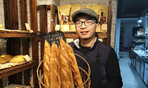 Thạc sĩ y khoa Huang chọn làm bánh mì vì đam mê. Thạc sĩ y khoa Huang chọn làm bánh mì vì đam mê. Ảnh: Hangzhou Daily.