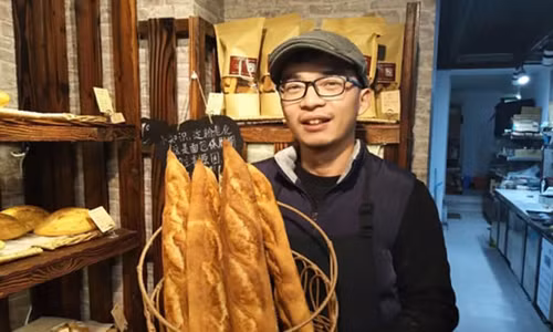 Thạc sĩ y khoa Huang chọn làm bánh mì vì đam mê. Ảnh: Hangzhou Daily.