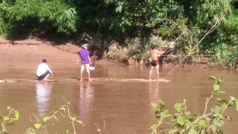 Giáo viên vượt suối lên bản vận động học sinh đến trường.