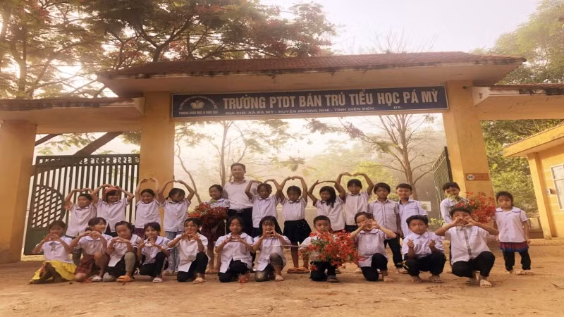 Hiệu trưởng nhà trường chụp ảnh lưu niệm cùng học sinh.