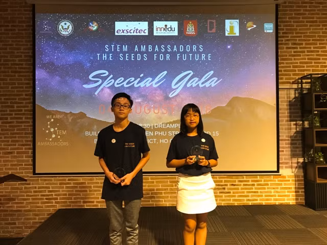 Tom Phí Trung Việt (trái) và Anna Ngô Trịnh Bảo Nhi (phải) đại diện SNA nhận kỷ niệm chương chứng nhận Đại sứ STEM.