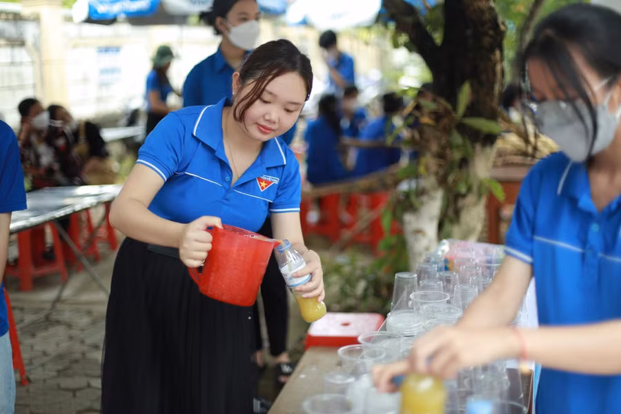 Đoàn thanh niên pha nước mía phục vụ thí sinh và phụ huynh tại điểm thi.