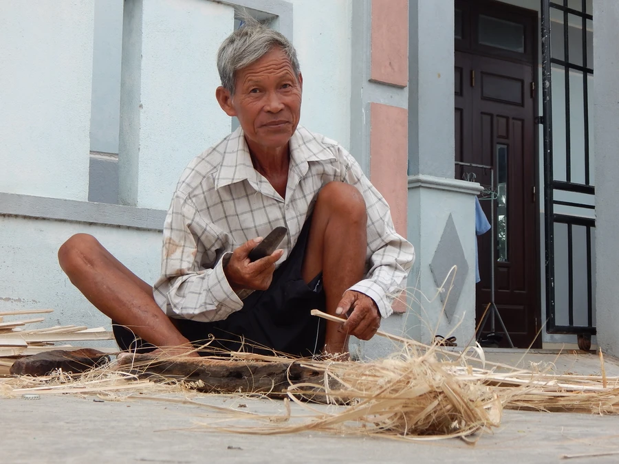 Mấy chục năm nay, thế ngồi đan vót của ông Liêm vẫn không thay đổi. Ảnh: T.G