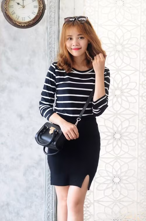 Phong cách nữ tính, dịu dàng với áo thun cổ tròn kẻ đen trắng dài và chân váy bút chì thun xẻ tà phù hợp với thời tiết không quá lạnh. 