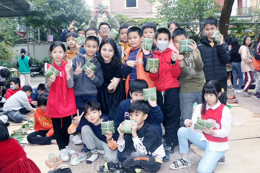 Cô Doãn Thị Hòa và các em học sinh lớp 5D bên thành quả của mình là những chiếc bánh chưng.