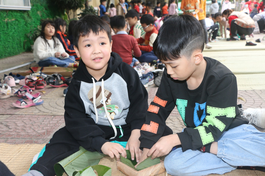 Học sinh lớp 3 lần đầu tiên được trải nghiệm gói bánh chưng tại trường.