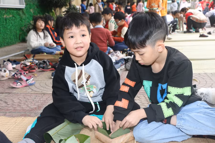 Học sinh lớp 3 lần đầu tiên được trải nghiệm gói bánh chưng tại trường.