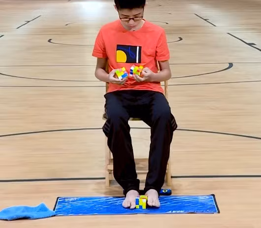 Que Jianyu xếp cùng lúc 3 khối rubik bằng cả tay lẫn chân