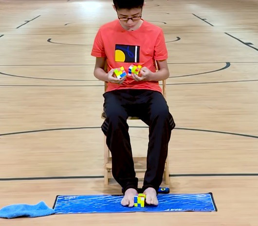 Que Jianyu xếp cùng lúc 3 khối rubik bằng cả tay lẫn chân Que Jianyu xếp cùng lúc 3 khối rubik bằng cả tay lẫn chân