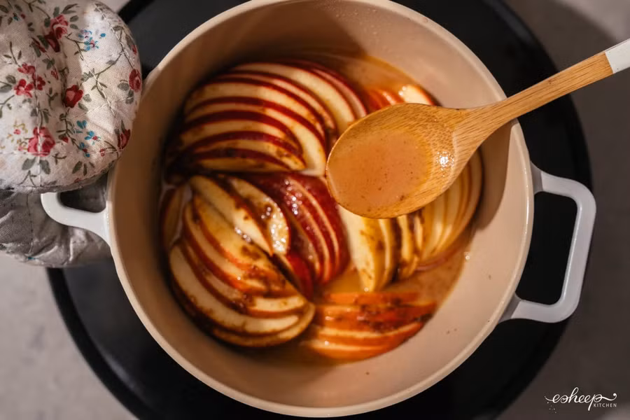 Nồi táo rim sau 30 phút, bạn nghiêng nồi, rưới nước táo lên các miếng bên trên cho đều.