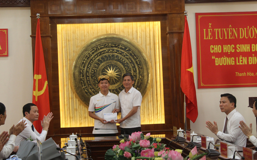 Đại diện Hội Khuyến học tỉnh Thanh Hóa trao thưởng cho em Lê Xuân Mạnh. Ảnh: LT.