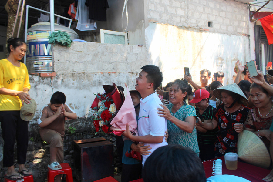 Xuân Mạnh được bà con chòm xóm ôm chầm chúc mừng. Ảnh: LT.