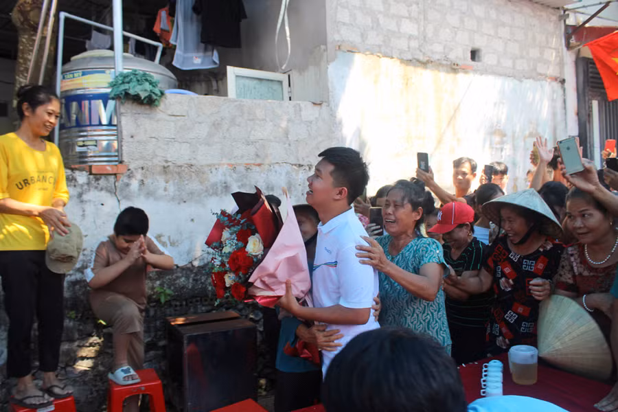 Xuân Mạnh được bà con chòm xóm ôm chầm chúc mừng. Ảnh: LT. Xuân Mạnh được bà con chòm xóm ôm chầm chúc mừng. Ảnh: LT.