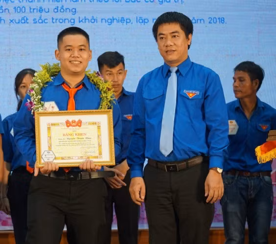 Nguyễn Thành Nhân (bên trái) nhận Bằng khen Thanh niên làm theo lời Bác.