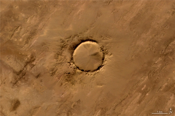 Chữ O: Miệng thiên thạch Tenoumer, nằm trên lãnh thổ nước Cộng hòa Hồi giáo Mauritanie, Tây Phi, được hình thành sau khi một thiên thạch đâm trúng Trái Đất từ cách đây 10.000-30.000 năm. Chữ O: Miệng thiên thạch Tenoumer, nằm trên lãnh thổ nước Cộng hòa Hồi giáo Mauritanie, Tây Phi, được hình thành sau khi một thiên thạch đâm trúng Trái Đất từ cách đây 10.000-30.000 năm.