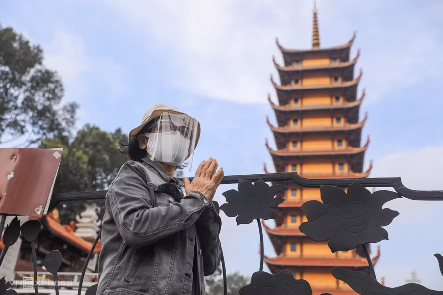 Trong buổi đại lễ cầu siêu, một số người thân nạn nhân chưa đăng ký vào kịp, đứng trước của chùa vái vọng. Ảnh: Vnexpress