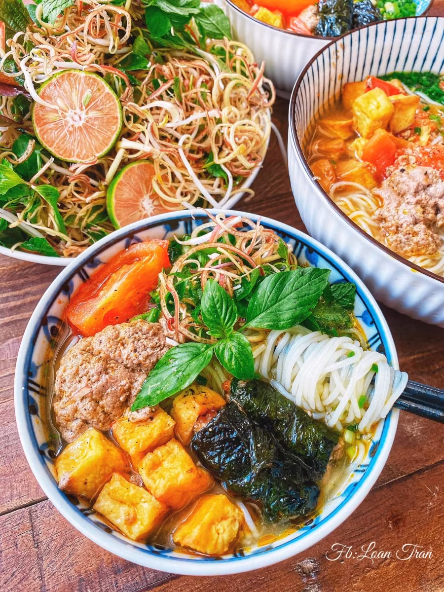 Tô bún riêu cua. Topping đơn giản chỉ có đậu phụ, chả lá lốt, thịt cua, cà chua... Mọi người có thể biến tấu topping tuỳ ý: sườn sụn, thịt bò, mọc, ốc... Ăn bún riêu cua với hoa chuối, giá đỗ và tất cả các loại rau thơm.