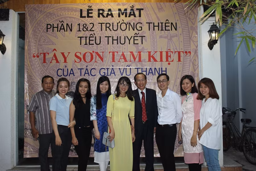 Nhà văn Vũ Thanh (thứ 4 từ phải sang) chụp hình với độc giả, bạn bè tại lễ lễ ra mắt 2 bộ tiểu thuyết