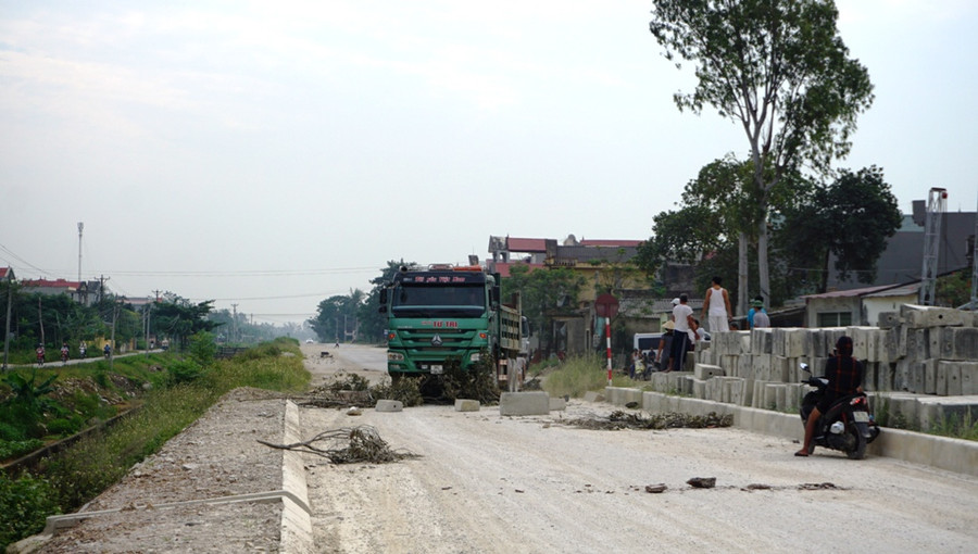 Một chiếc xe tải bị dân dùng vật liệu chặn đường.