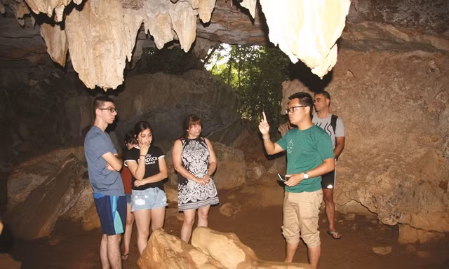 Hướng dẫn viên đang giới thiệu với du khách cấu tạo địa chất, địa mạo hang hồ Động Tiên